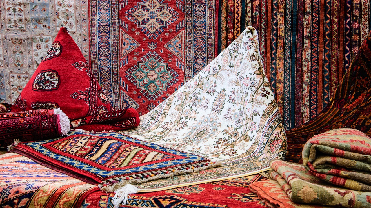 Pile of different types of oriental rugs at a market