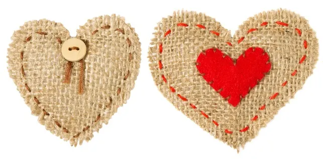 Three hearts made from burlap and decorated and used for hanging on a wall for home decor